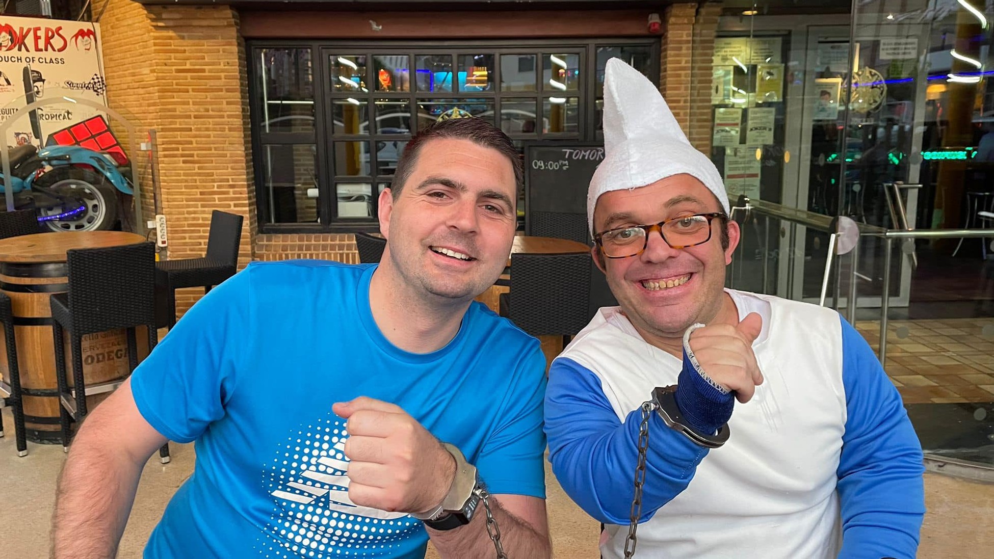Stag do group enjoying Benidorm nightlife with dwarf handcuff prank